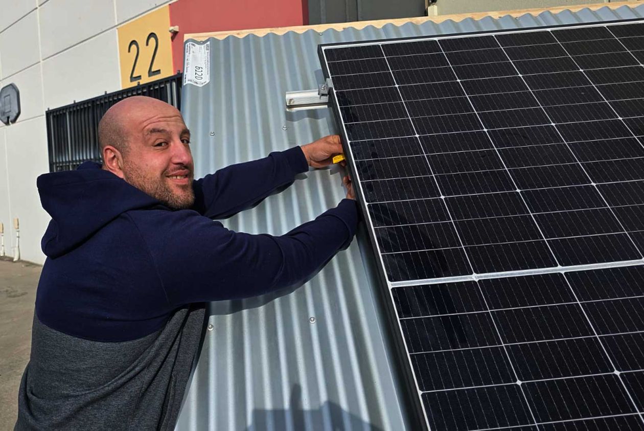 Student practising solar panel installation on a training rig during a hands-on class session